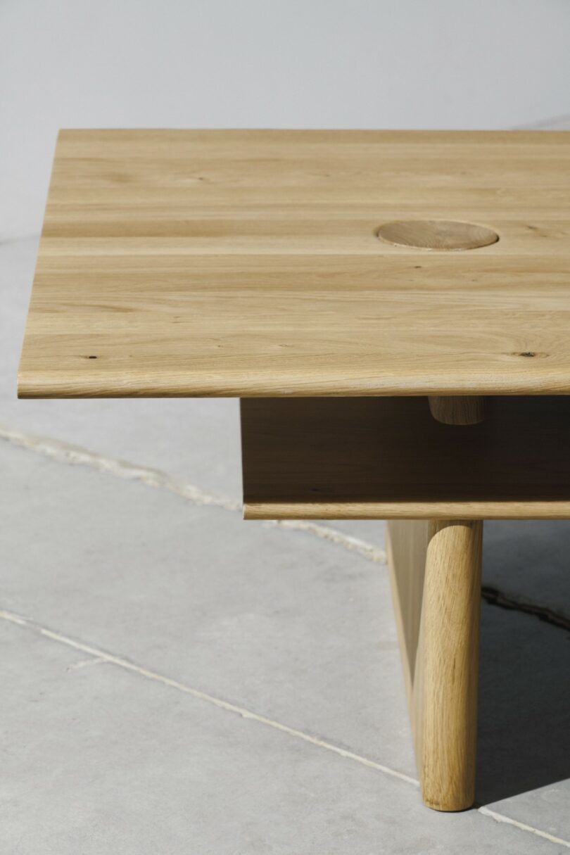 A minimalist rectangular wooden coffee table with a circular indentation and rich grain pattern.