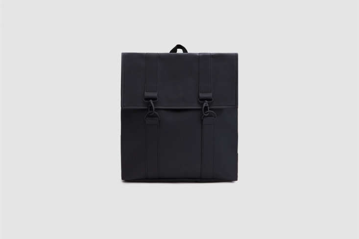 A matte black waterproof backpack hanging on a peg.