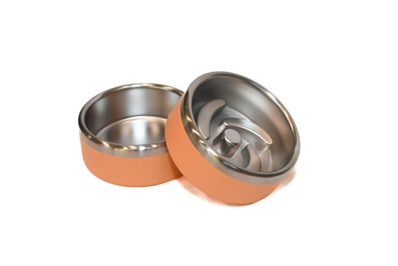 Detailed view of two orange mechanical-style pet feeder components showing interior curves.
