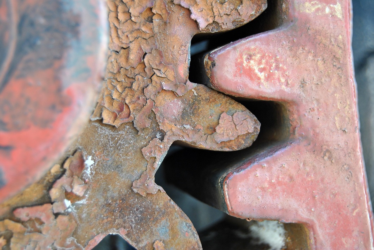 A close-up view of the mechanical components and copper piping of a refrigerator cooling system.