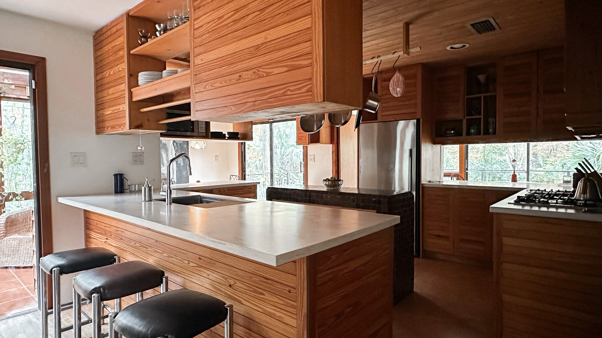 A modern kitchen view featuring a new passthrough to the dining room and custom wood cabinetry.