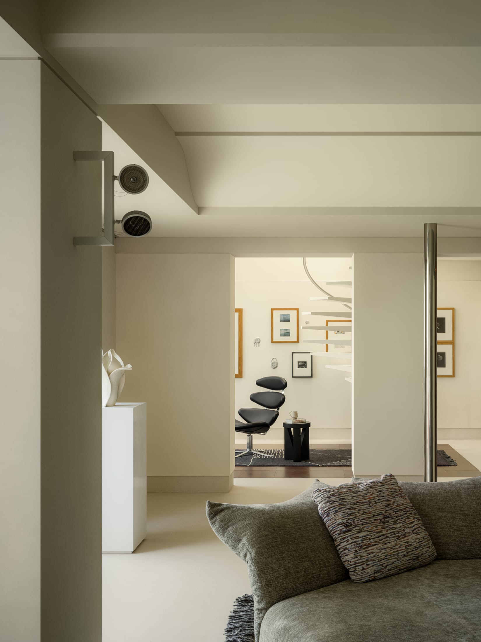 Close-up of sunlight filtering through leaves onto a textured stone wall in a minimalist interior.