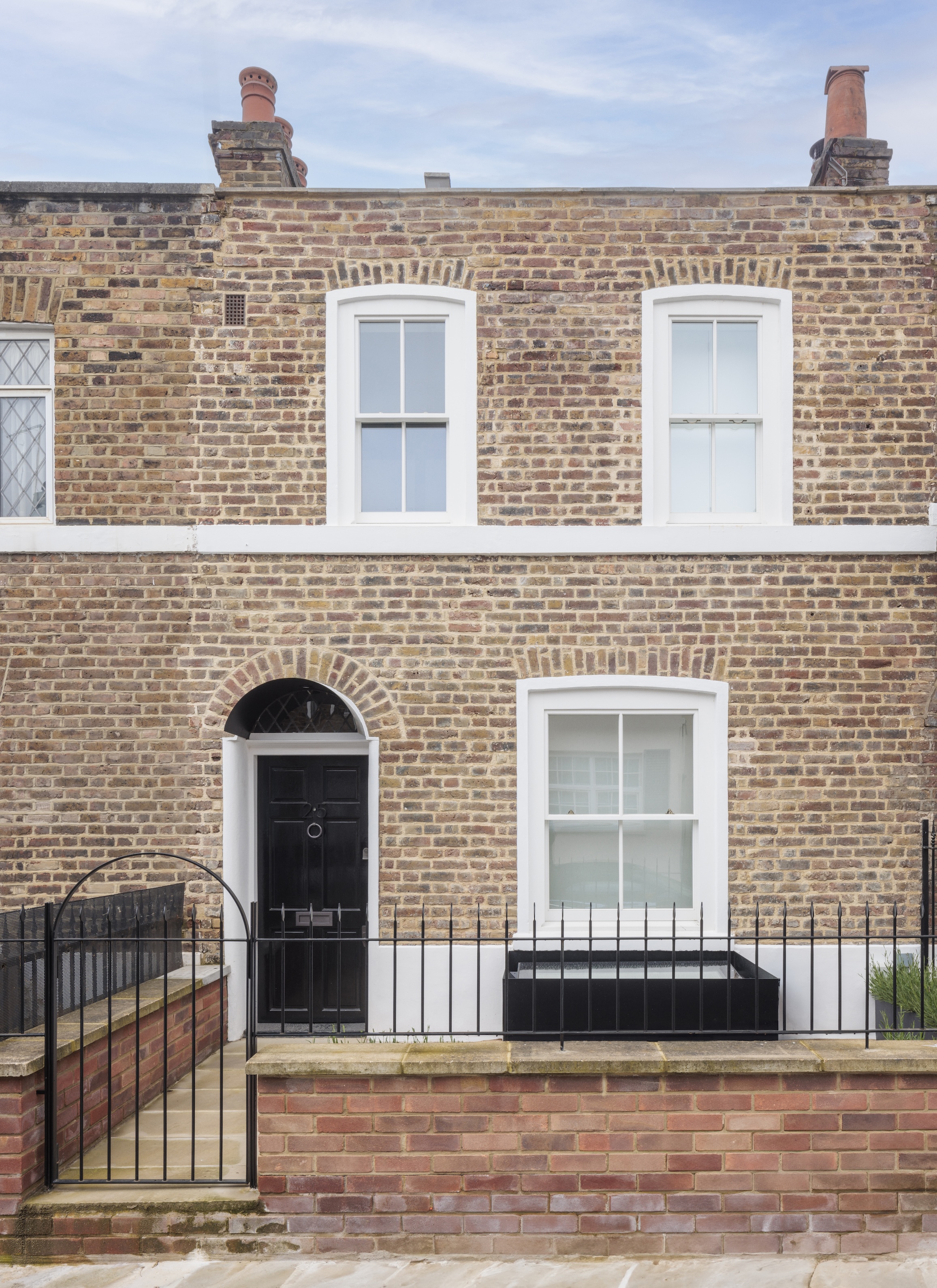 A dark, water-damaged interior of a London townhouse before renovation.