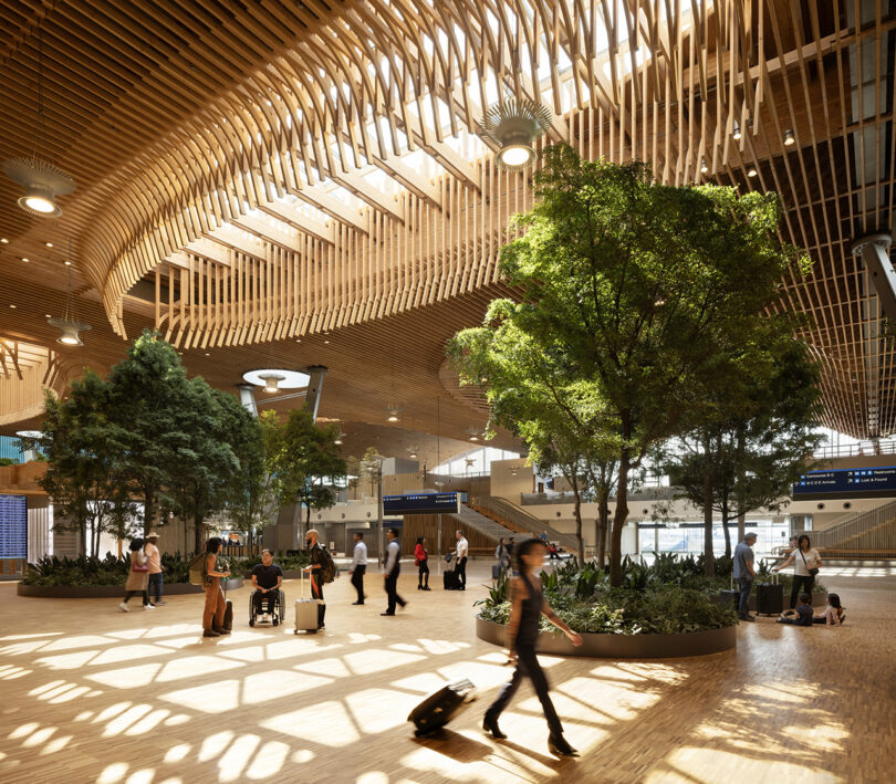 Travelers with luggage walking under a sunlit wooden lattice ceiling.