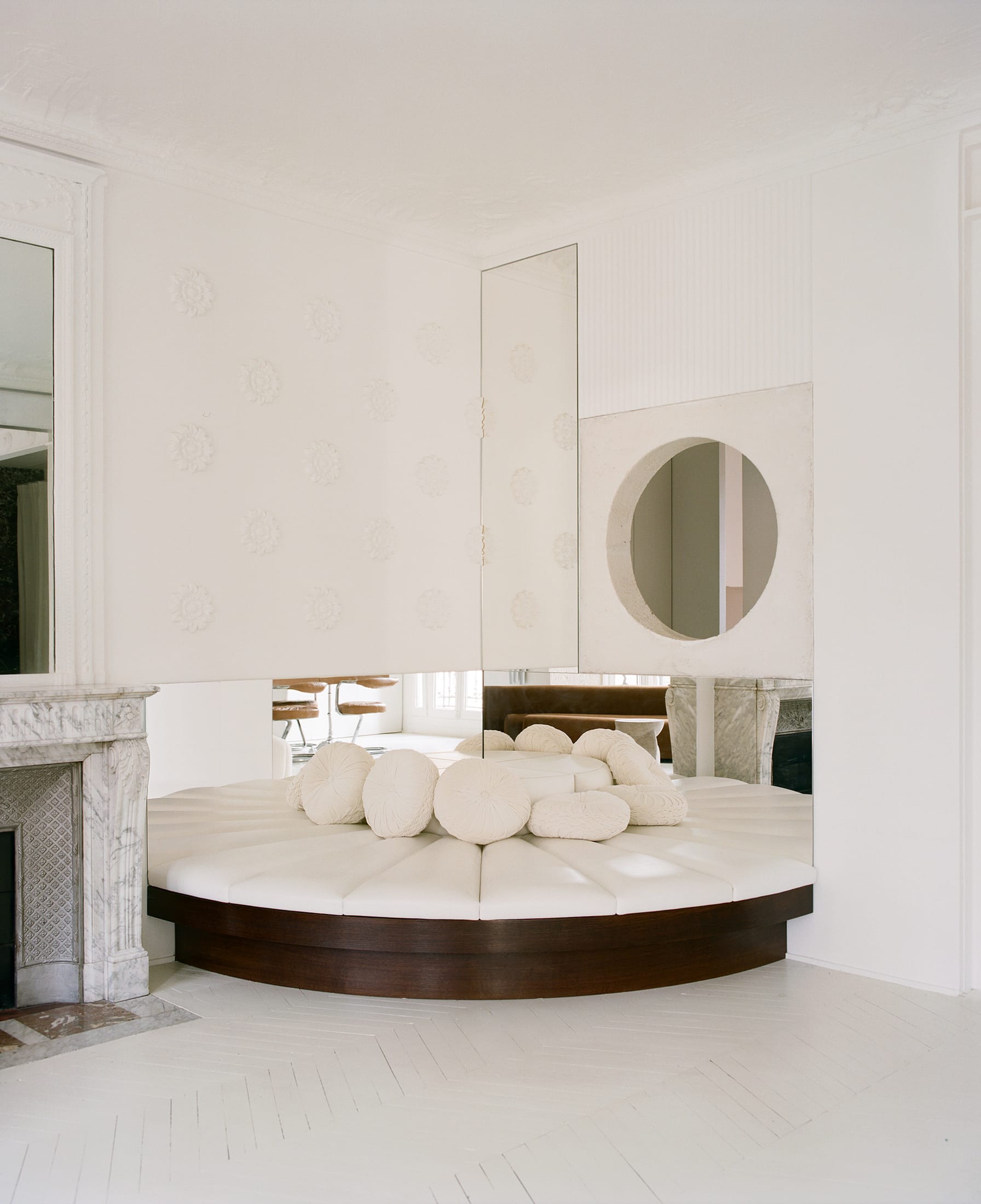 A large white marble bathtub integrated into a modern living room setting near a window.