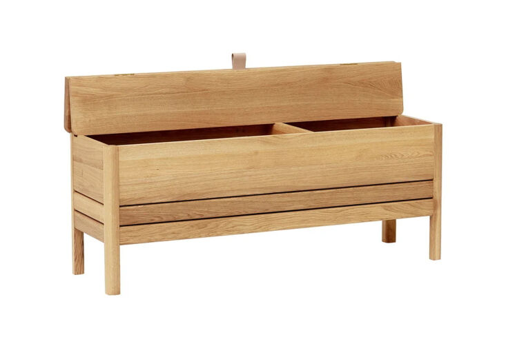 A light European oak storage bench featuring a small leather loop for opening the lid.
