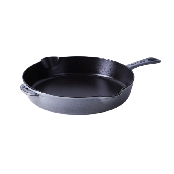 A close-up of salsa verde being drizzled over a perfectly cooked piece of white fish.