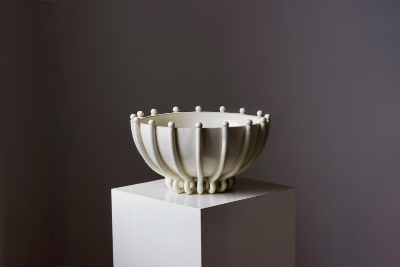 A white, intricately designed ceramic bowl with textured surface and rounded protrusions.