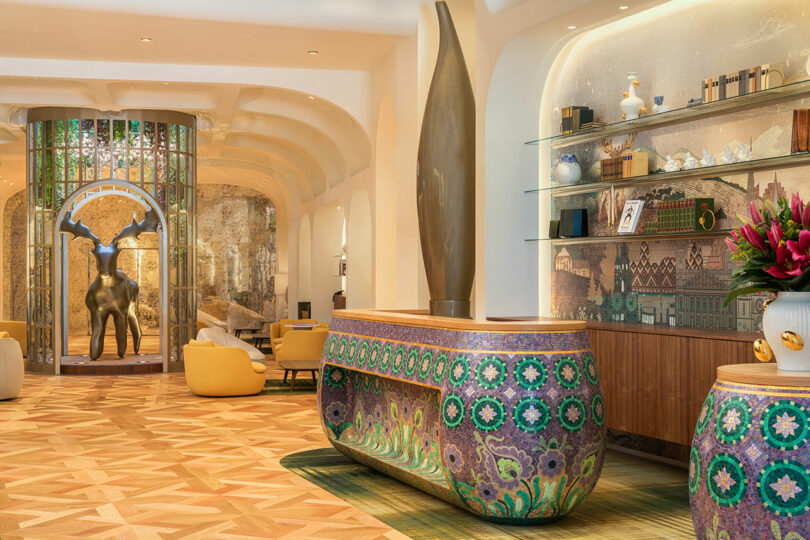 The hotel lobby featuring a golden deer statue and geometric patterned flooring.