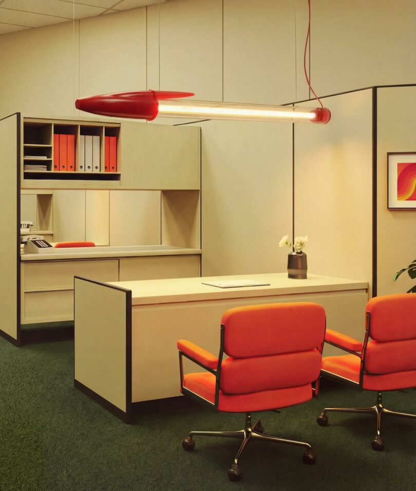 A red BIC pendant light hanging from the ceiling in a modern office with red chairs.