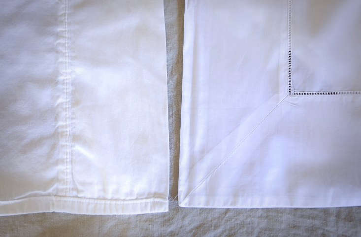 Two different white sheets compared side-by-side, with the Sferra sheet on the right appearing more substantial and finely finished.