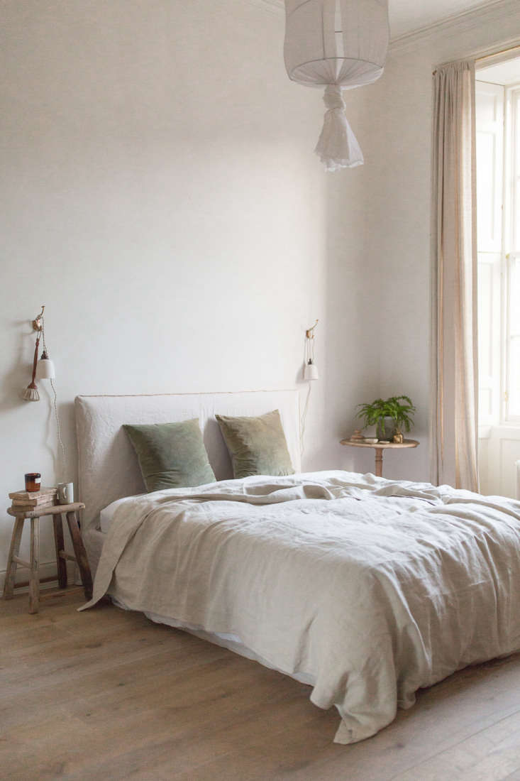 Close-up of a bedroom wall with neutral limewash paint showing subtle brushstroke textures.