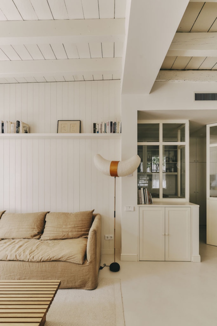 A living room featuring a linen sofa, an Akari floor lamp, and a custom wood coffee table.