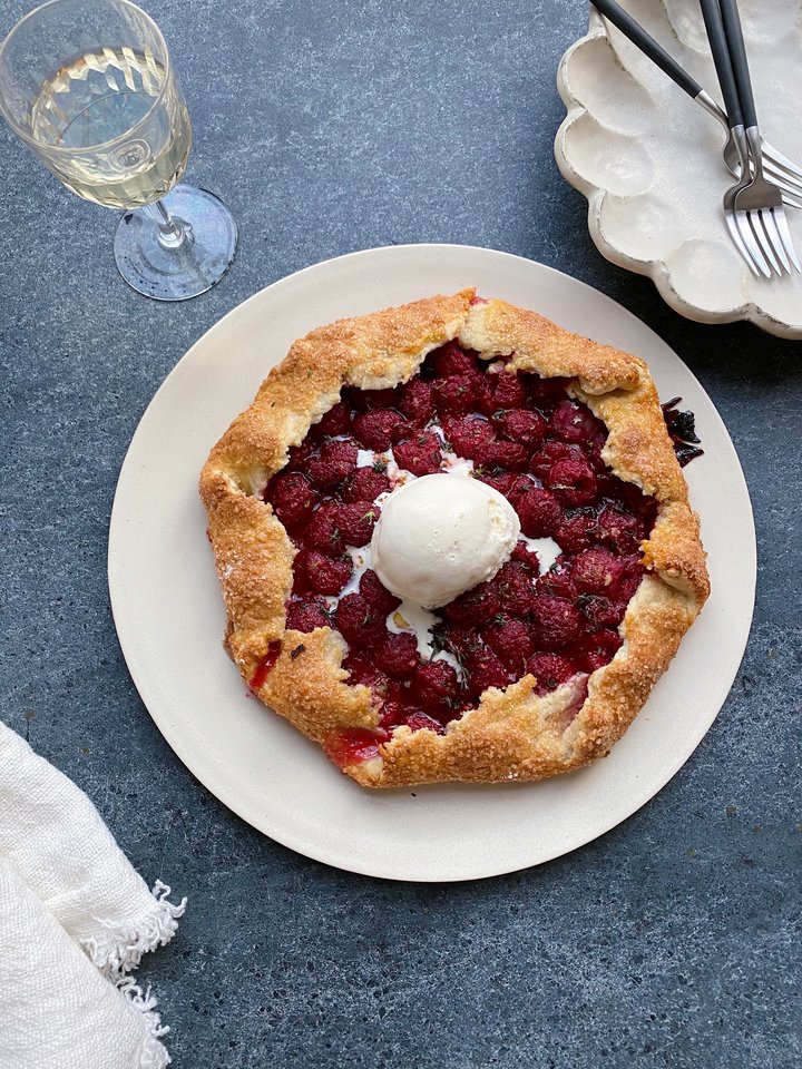 A harvest grain bowl topped with roasted delicata squash, kale, and pomegranate seeds.