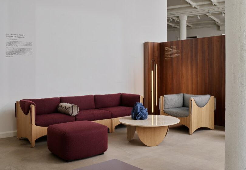 A deep burgundy modular sectional sofa with a matching ottoman in a minimalist room.