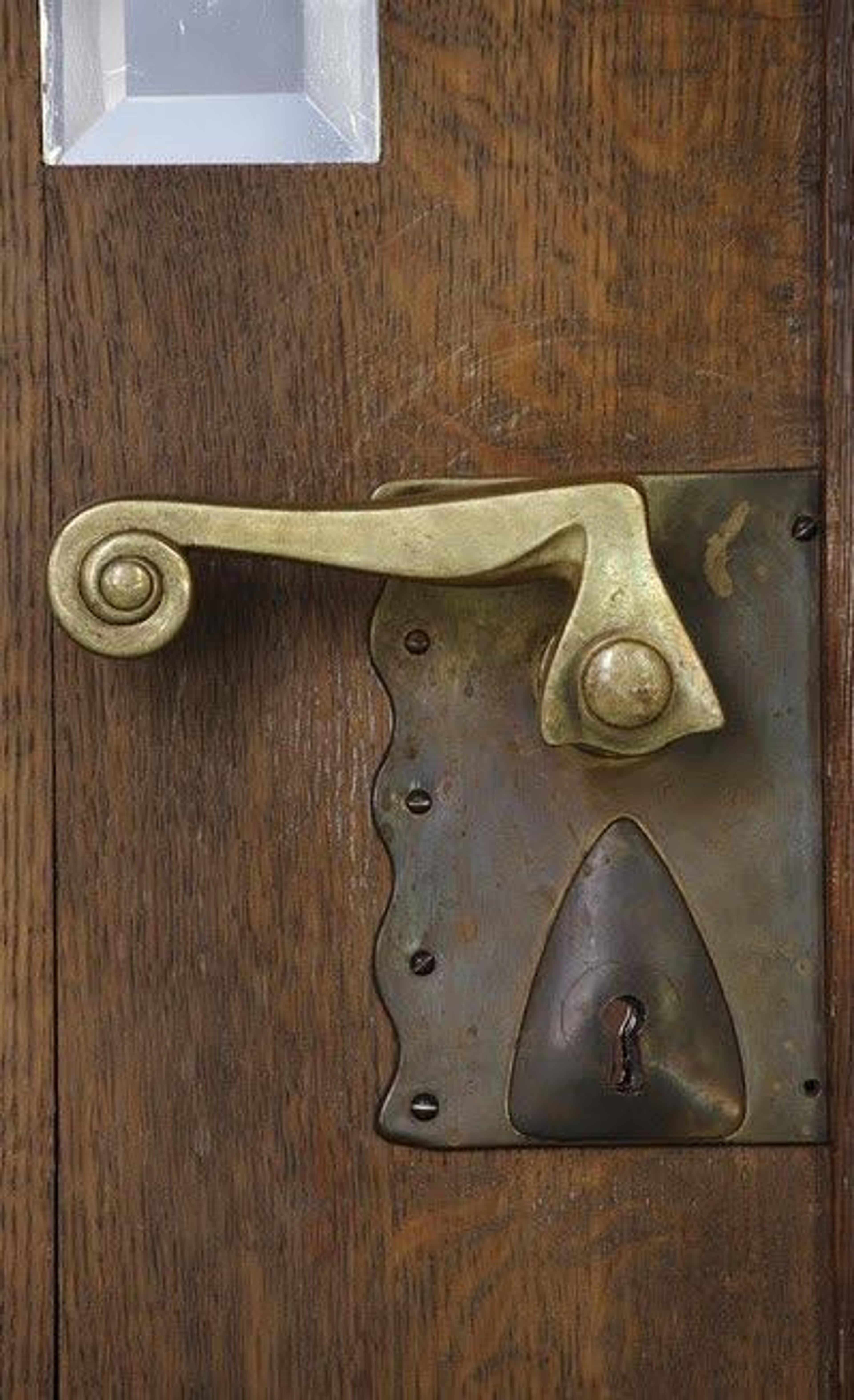 Extreme close-up of a sleek, ergonomic metal door pull highlighting its finish.