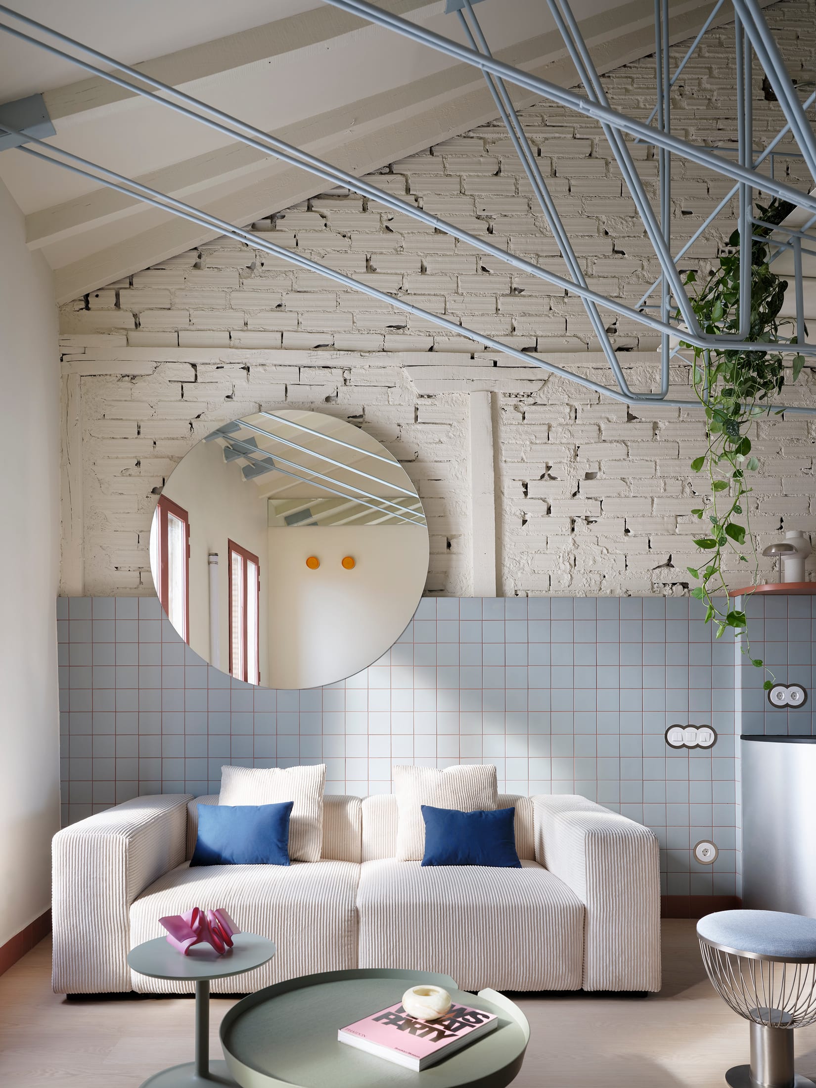Interior shot of Casa Cometa showing the open-plan ground floor and the suspended sky-blue mezzanine.