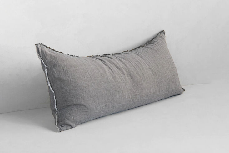 The Hale Mercantile Co. Flocca Linen Body Pillow in a muted gray 'Rok' color with frayed edges.