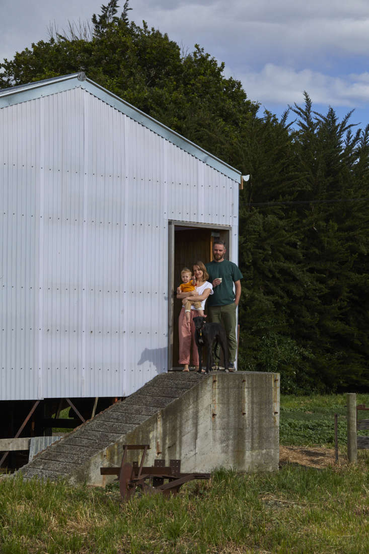 Exterior view of the corrugated metal sheep shed with the original concrete ramp and the Daly family.