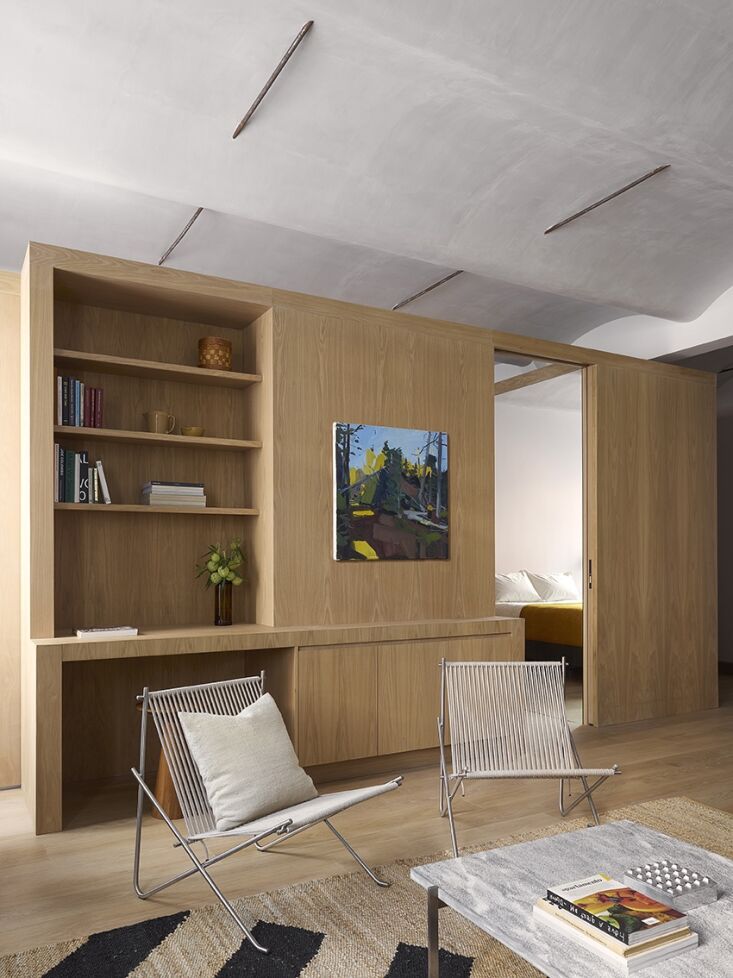 A minimalist dining setup with a round table, a classic PK4 chair, and an Akari paper pendant lamp.