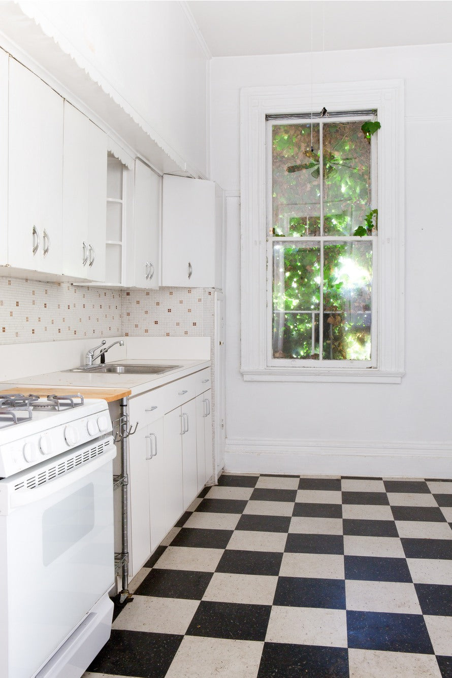 Modern kitchen interior showing the replacement of upper cabinets with a sleek marble slab shelf.