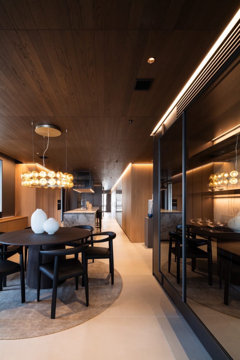 Modern dining area showing the continuity between dark oak wall panels and ceiling structures.