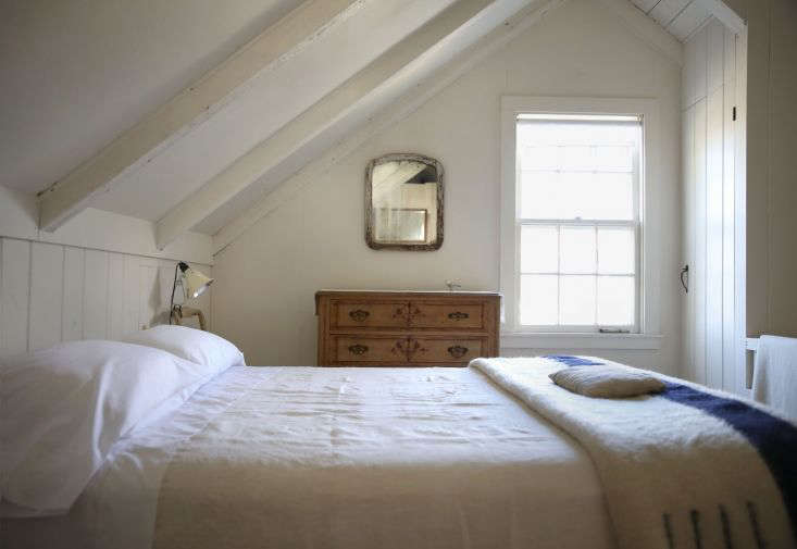 Bright white Sferra sheets spread out on a bed in a sunlit room.