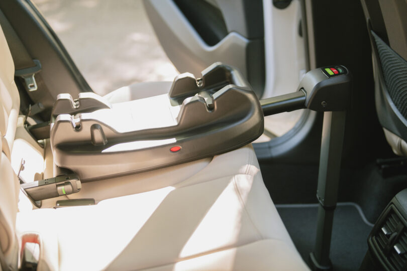 A close-up of the Tavo ISOFIX vehicle base installed on a car seat.