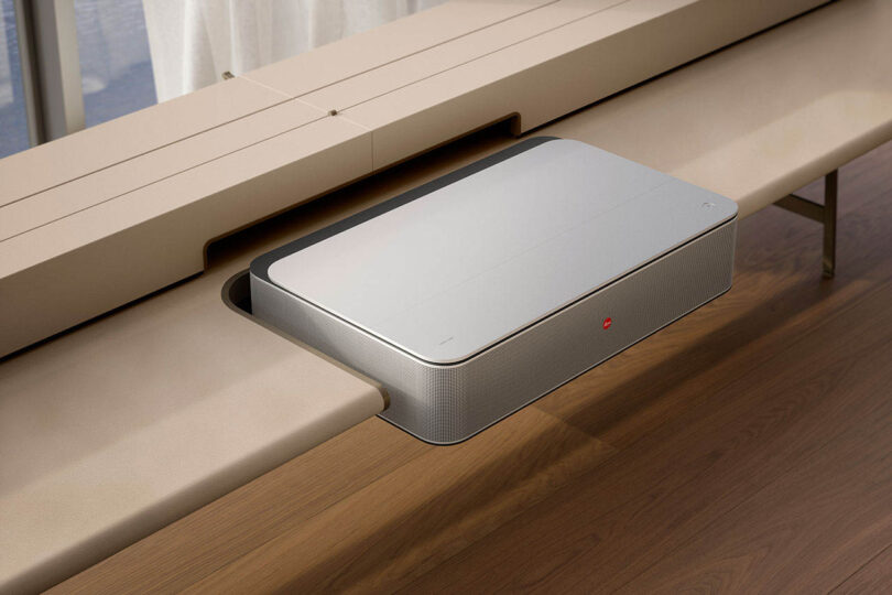 A sleek electronic device integrated into a beige leather and wood bench.