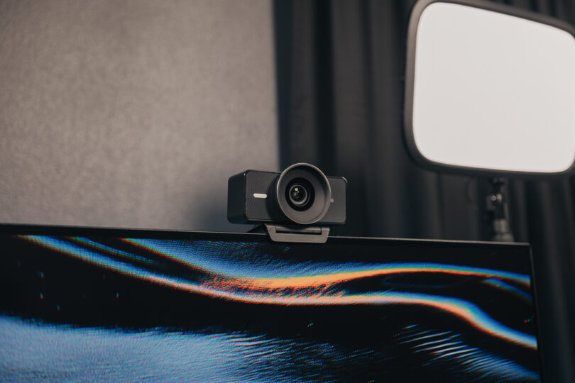 Elgato webcam mounted on a monitor with a professional studio light in the background.