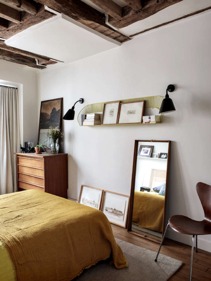 A master bedroom featuring mid-century modern furniture and textured bedding.