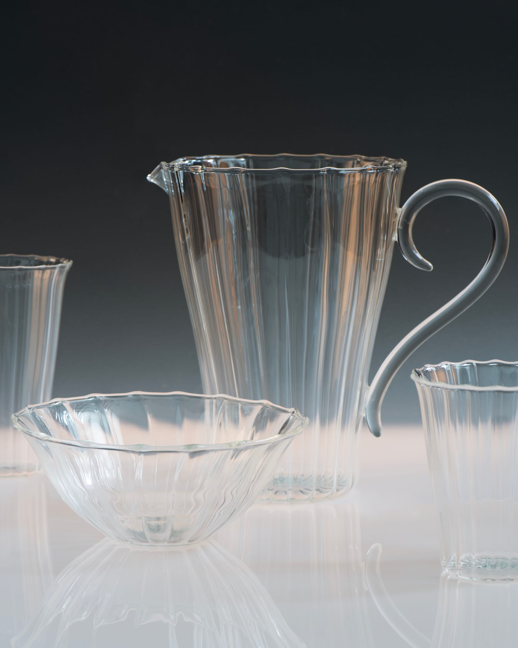 A sculptural amber pitcher alongside decorative glass fish, demonstrating 1930s influence.