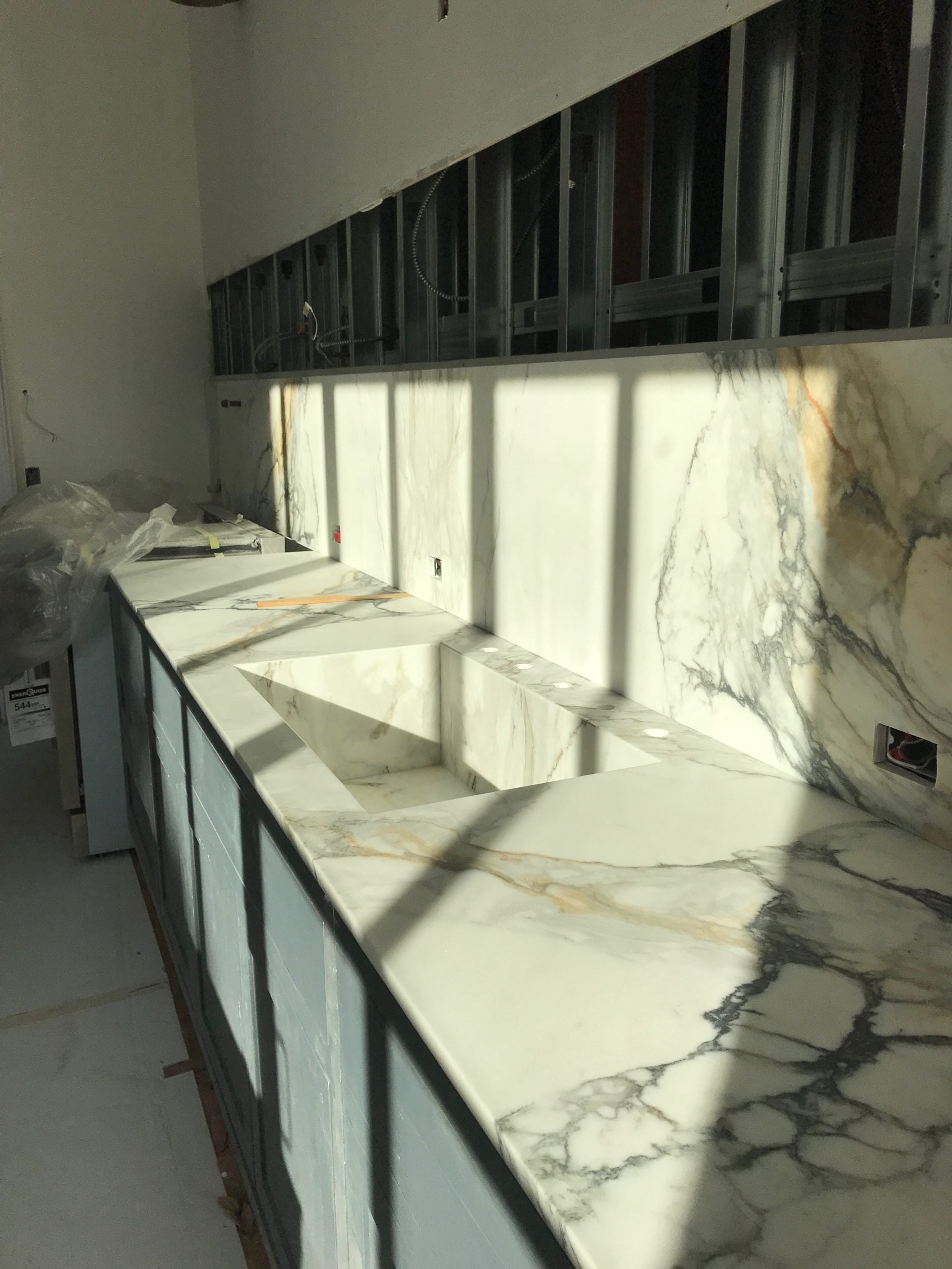 Dramatically veined marble shelf integrated with white oak cabinetry and matte hardware.