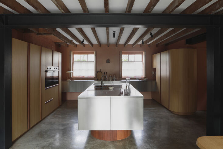 Custom oak and sapele wood kitchen cabinetry with a minimalist, furniture-like appearance.