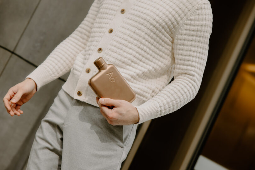 Close-up of a person holding the Copper PVD A6 memobottle.
