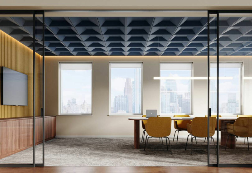 Professional conference room with blue geometric ceiling panels and yellow chairs.