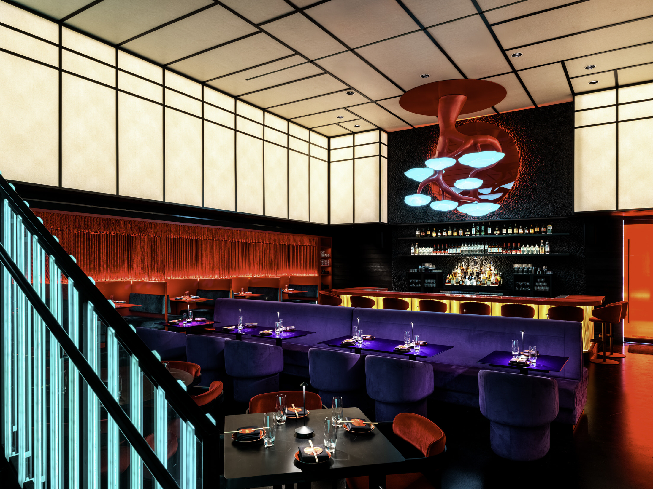 Dark shou sugi ban wooden stairs leading to a mezzanine with glass balustrades.