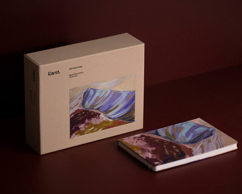 A boxed puzzle and matching notebook featuring abstract mountain artwork.