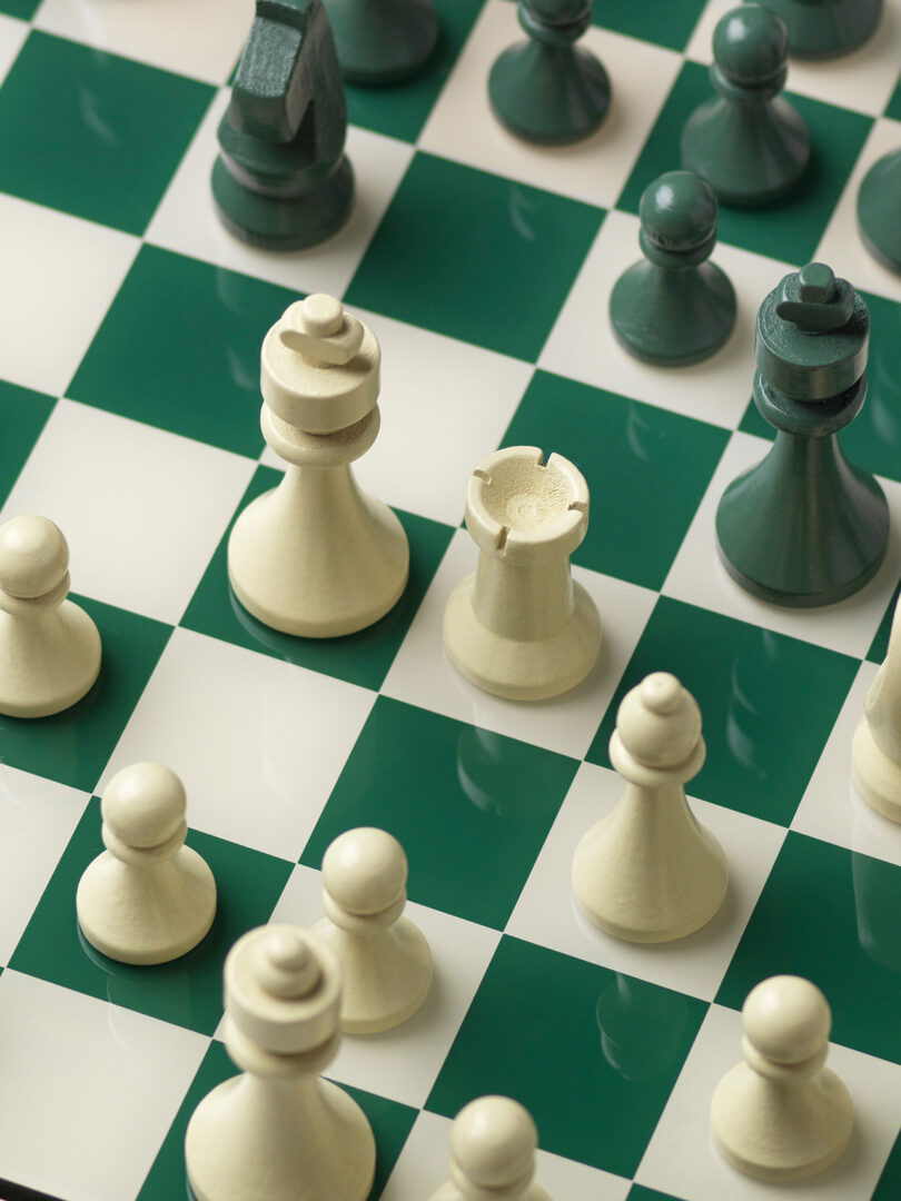 A green and white chessboard showing pieces mid-game with focus on the white pieces.