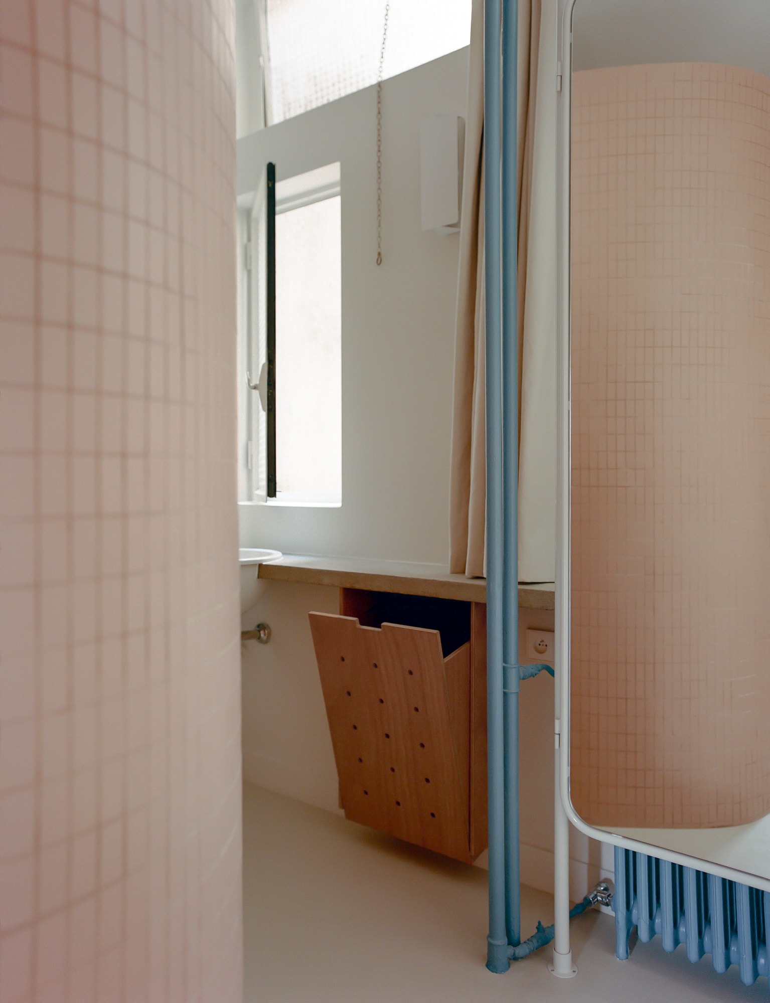 Detail shot of the blue-grey cabinetry and wooden textures in the restored apartment.