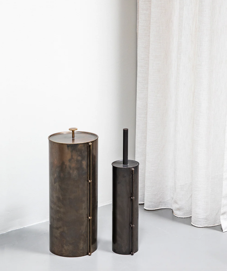 Luxury bathroom accessories including a Heritage bin and brush set in polished brass.