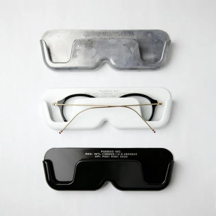 Aluminum die-cast glasses holders mounted vertically on a wall surface.