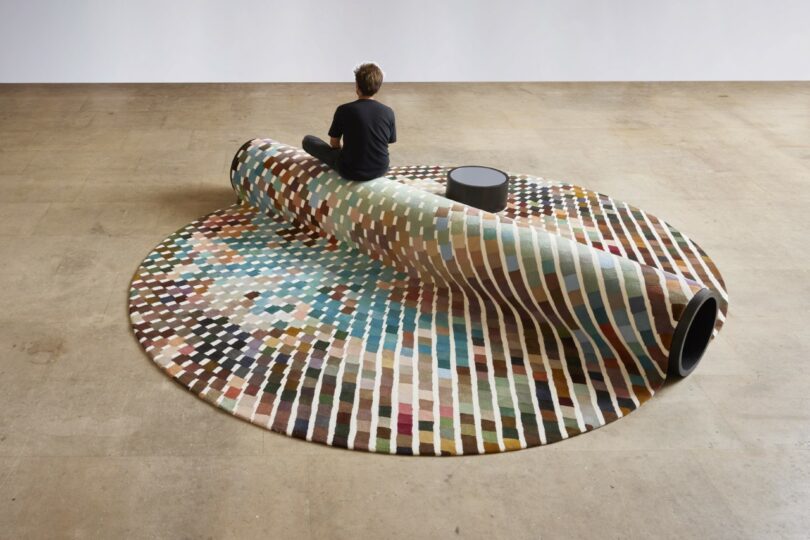 A person sitting on a modular seating system, highlighting its use as a social crossroads.