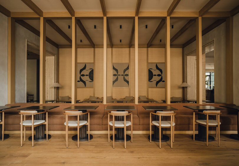 Interior of MUND restaurant with wooden beams, abstract art, and modern seating.