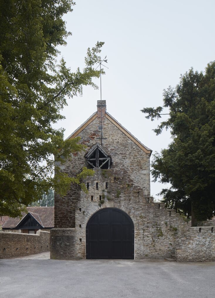The arched entrance and stone rubble balustrade of the historic Wool Hall.