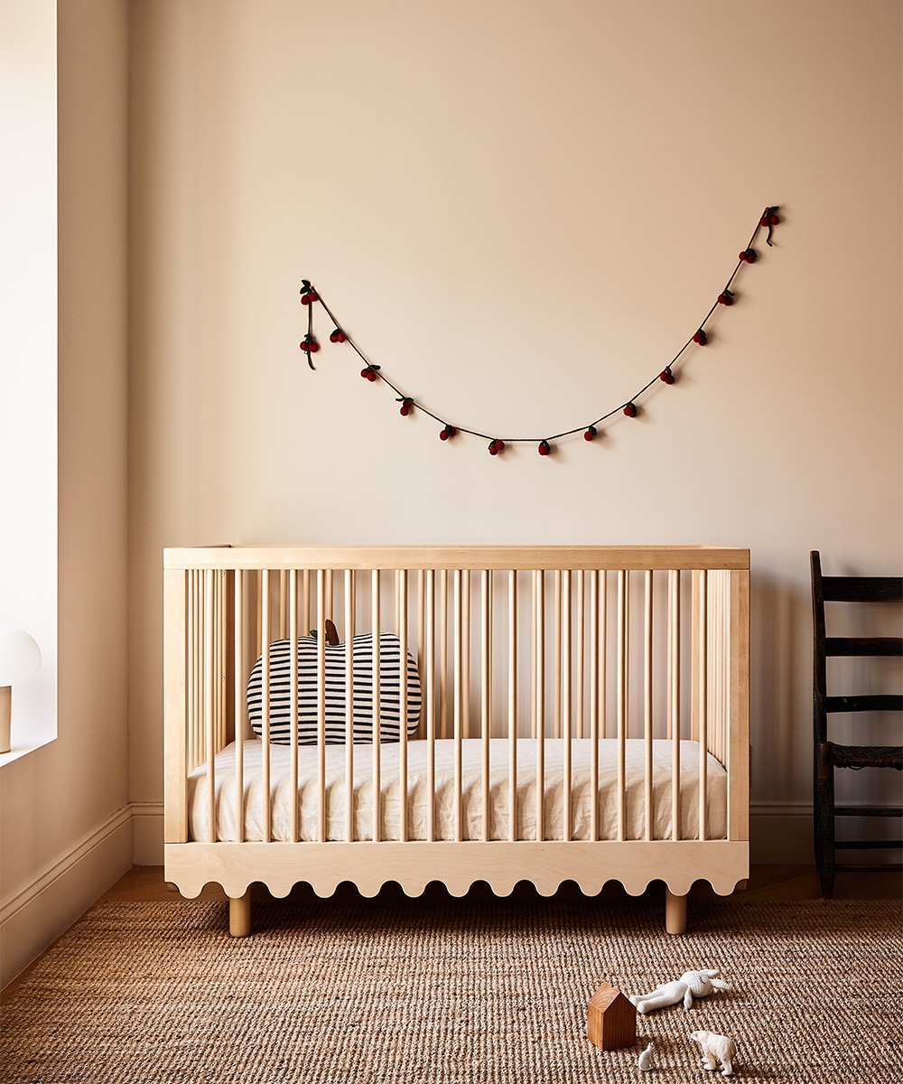 The Oeuf Moss Crib converted into a toddler bed with eco-friendly bedding.