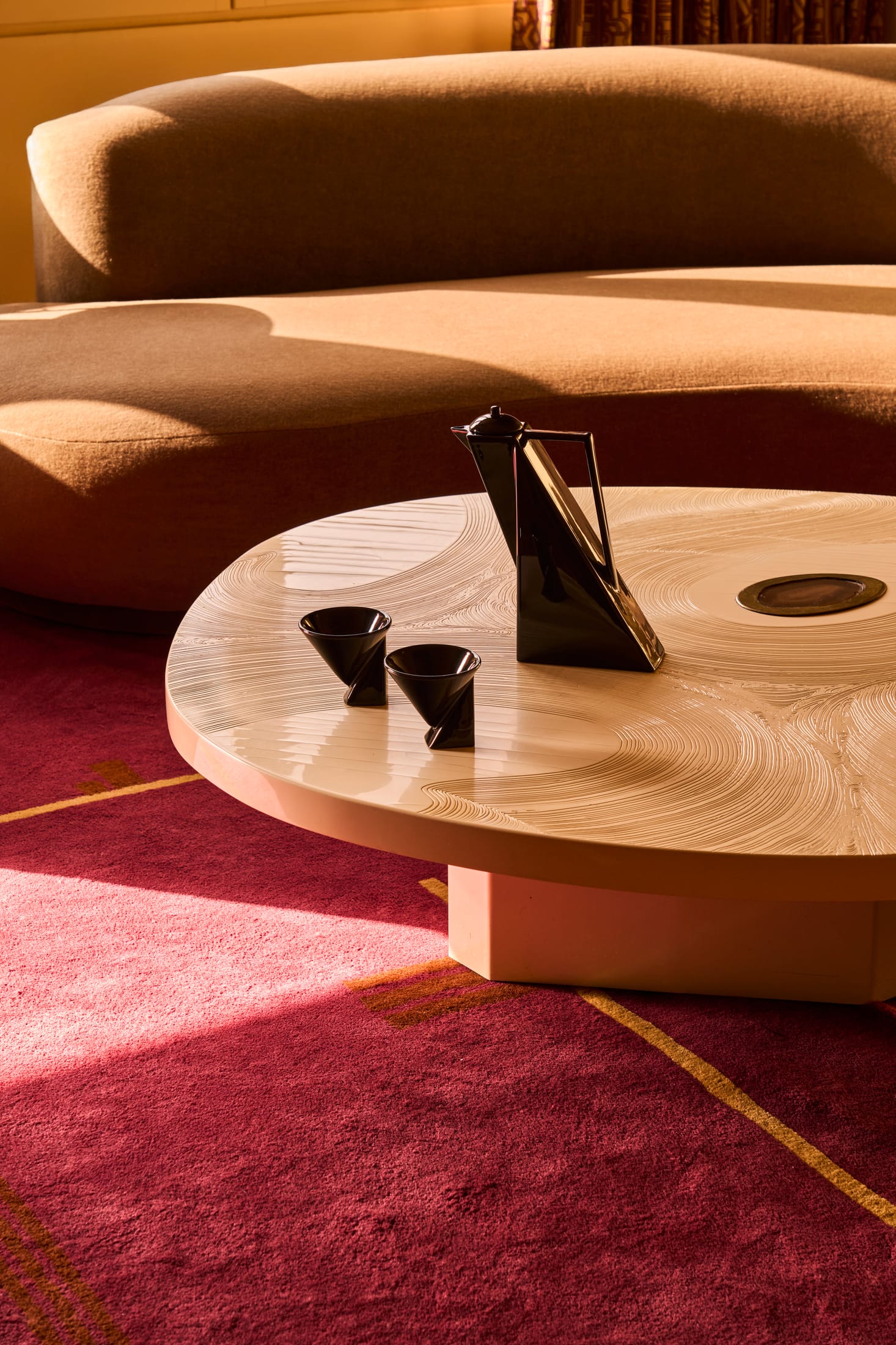 A workspace corner featuring a mix of low lounge seating and taller work tables.