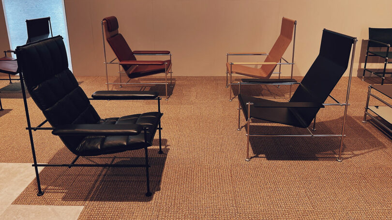 Minimalist lounge chairs with metal frames and leather seats arranged on a woven mat.