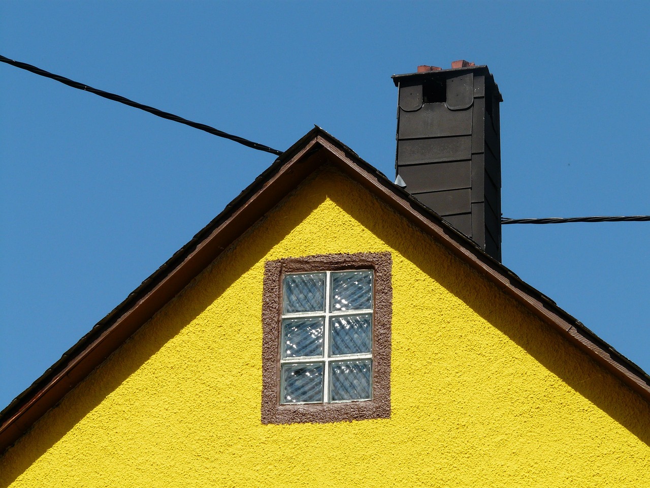 Freshly painted white roof gable with clean aluminum flashing seams.