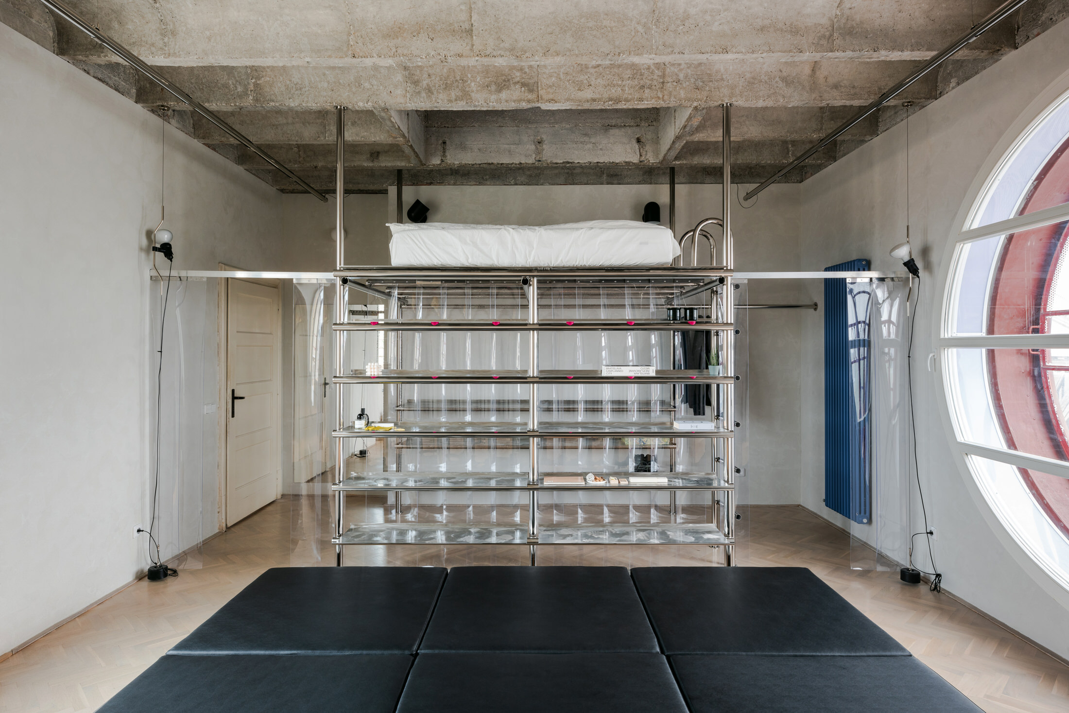 Panoramic view of the open-plan Kotva apartment showing the transition from living area to the timber platform.